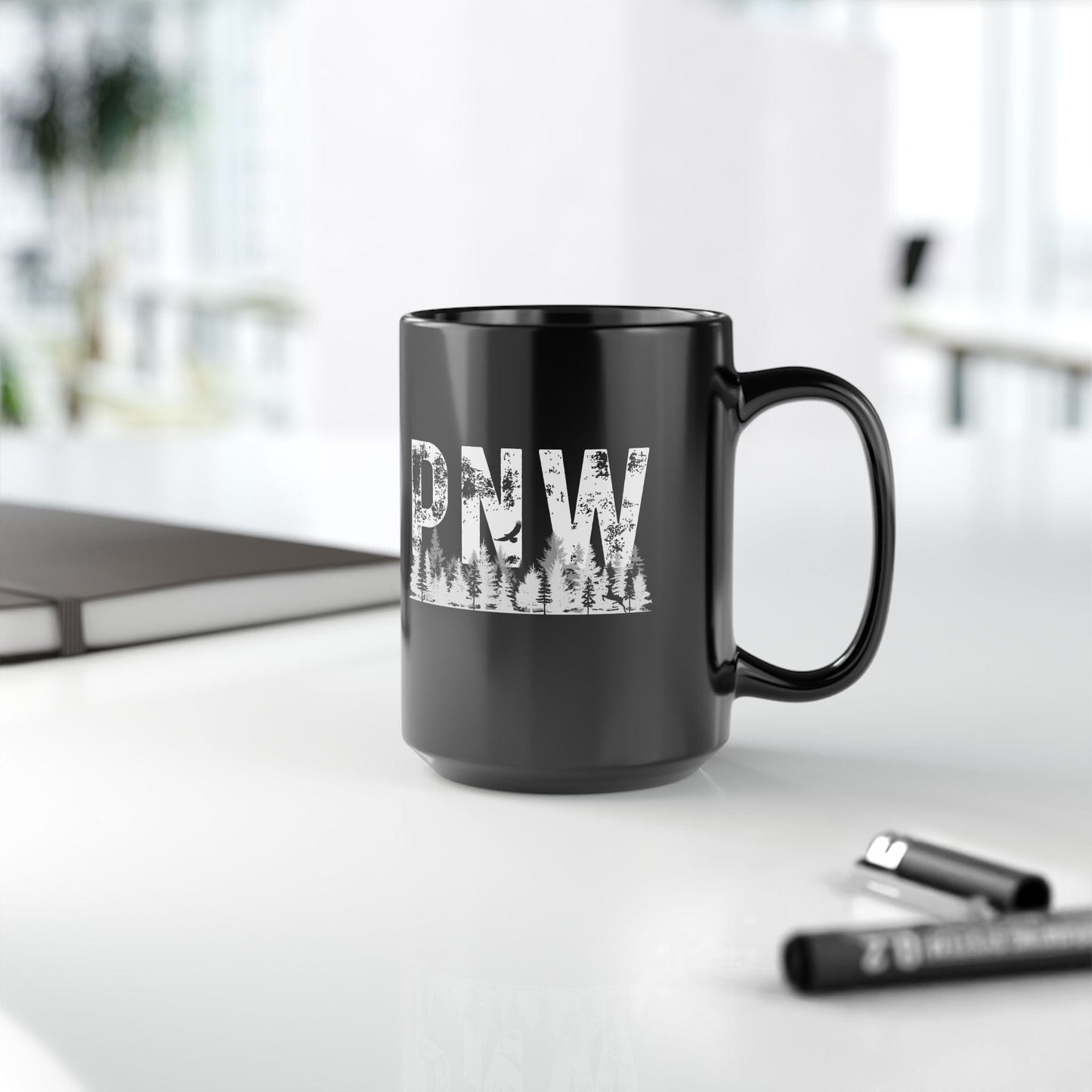 Black mug with 'PNW' text on a desk with office items