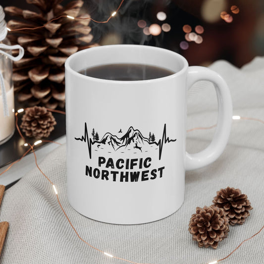 White mug with 'Pacific Northwest' design on a table with decorative items
