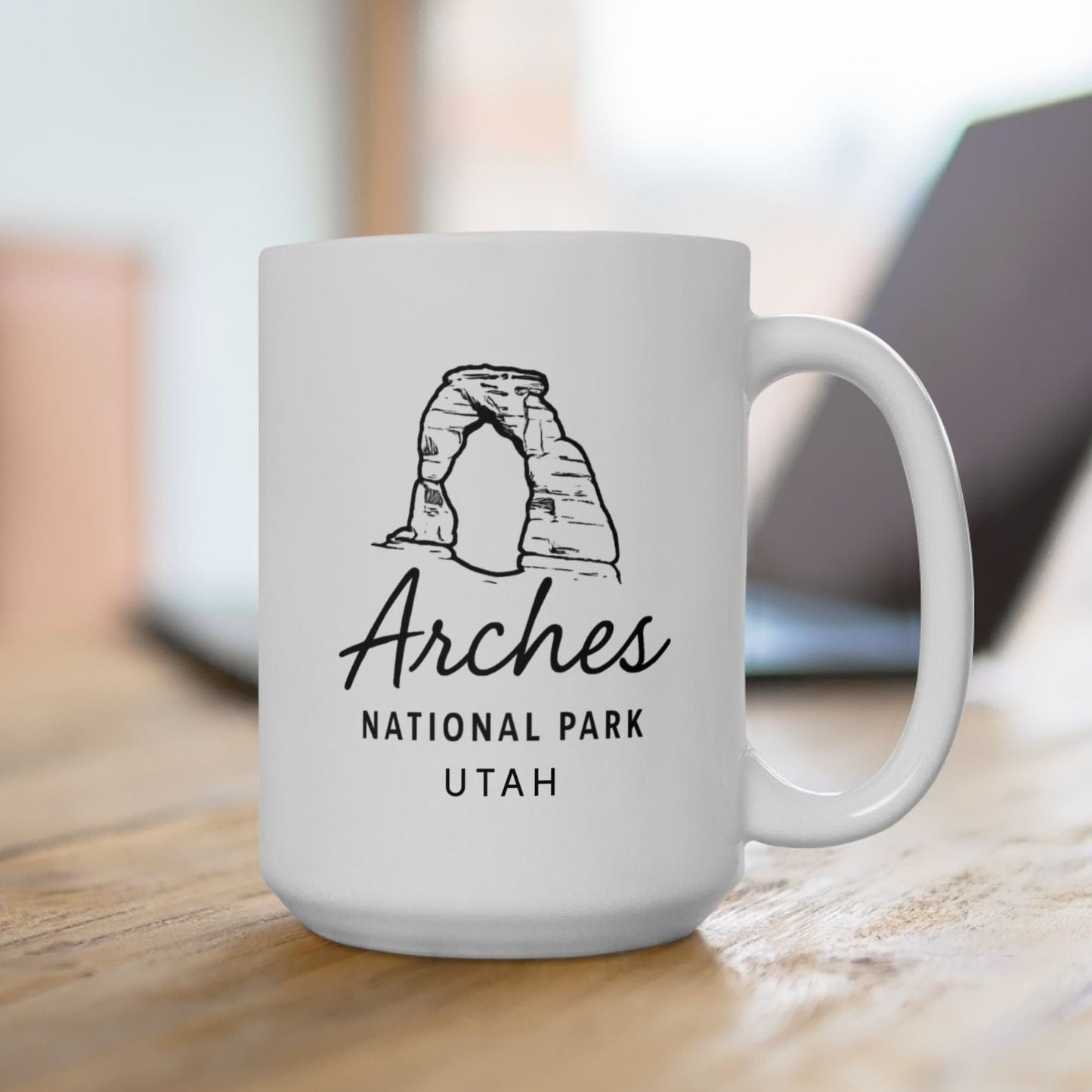 White mug with Arches National Park Utah design on a wooden surface