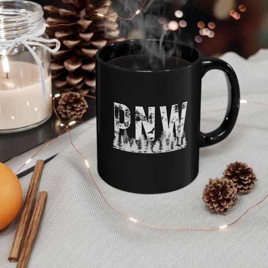 Black mug with 'PNW' design on a table with decorative items