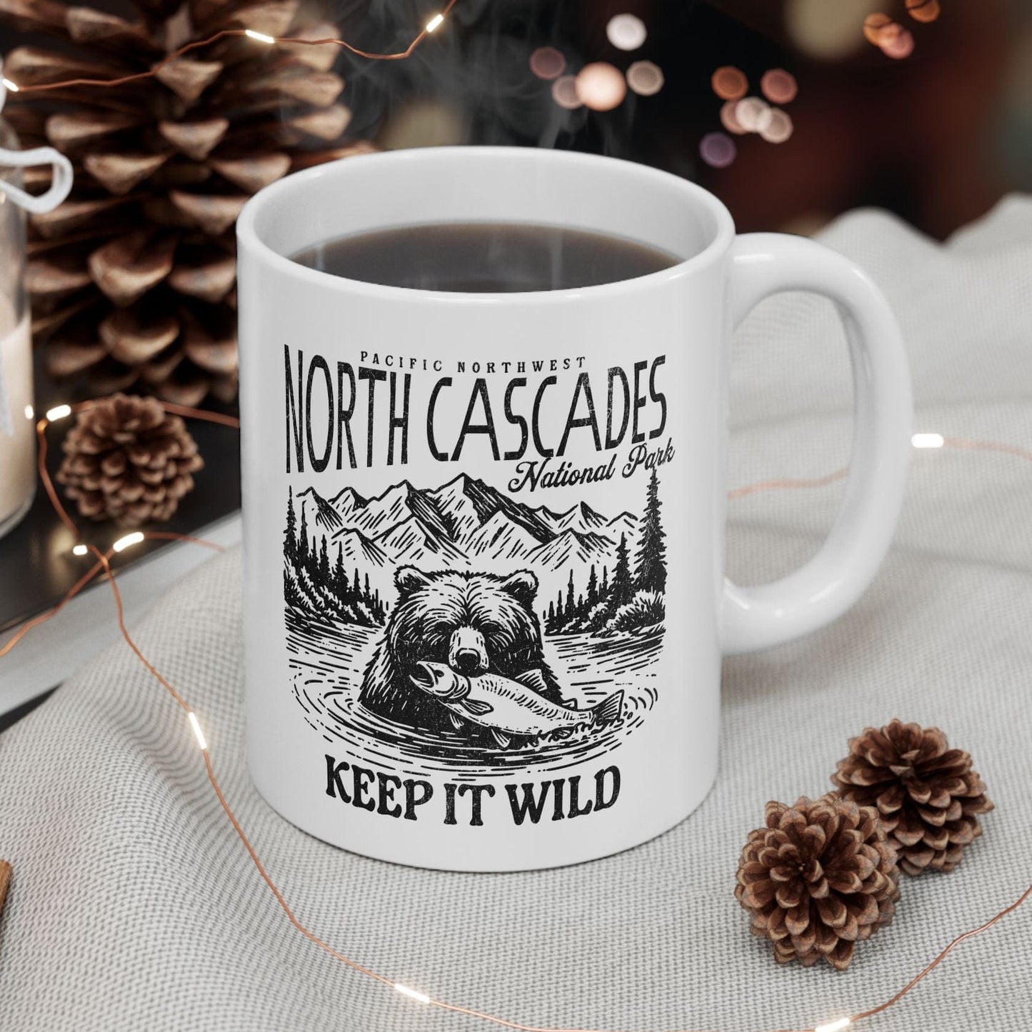 White mug with 'North Cascades National Park' design on a table with decorative items