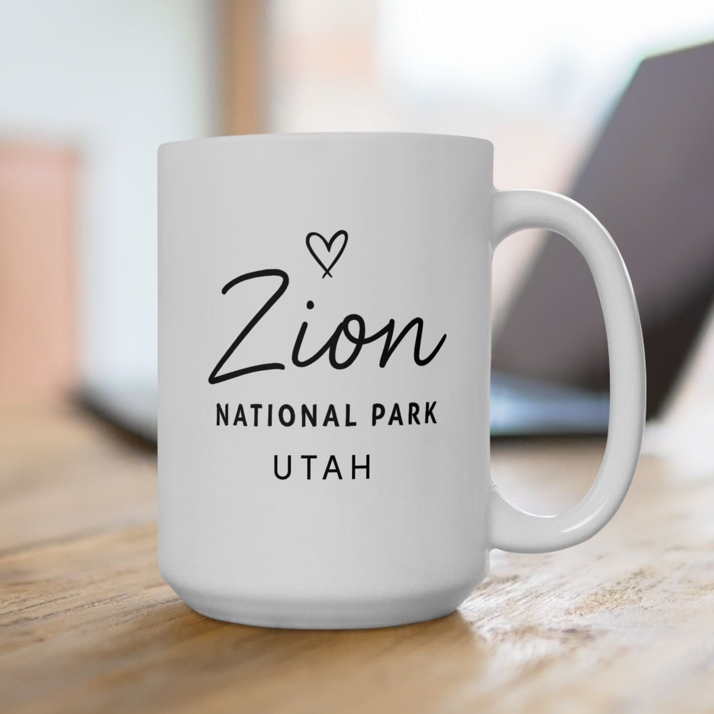 White mug with 'Zion National Park Utah' text on a wooden surface