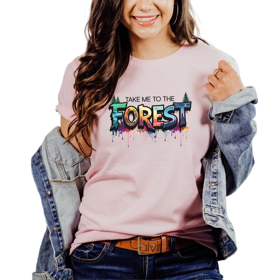 A woman wearing a pink t-shirt with the text 'Take Me to the Forest' printed on the front.
