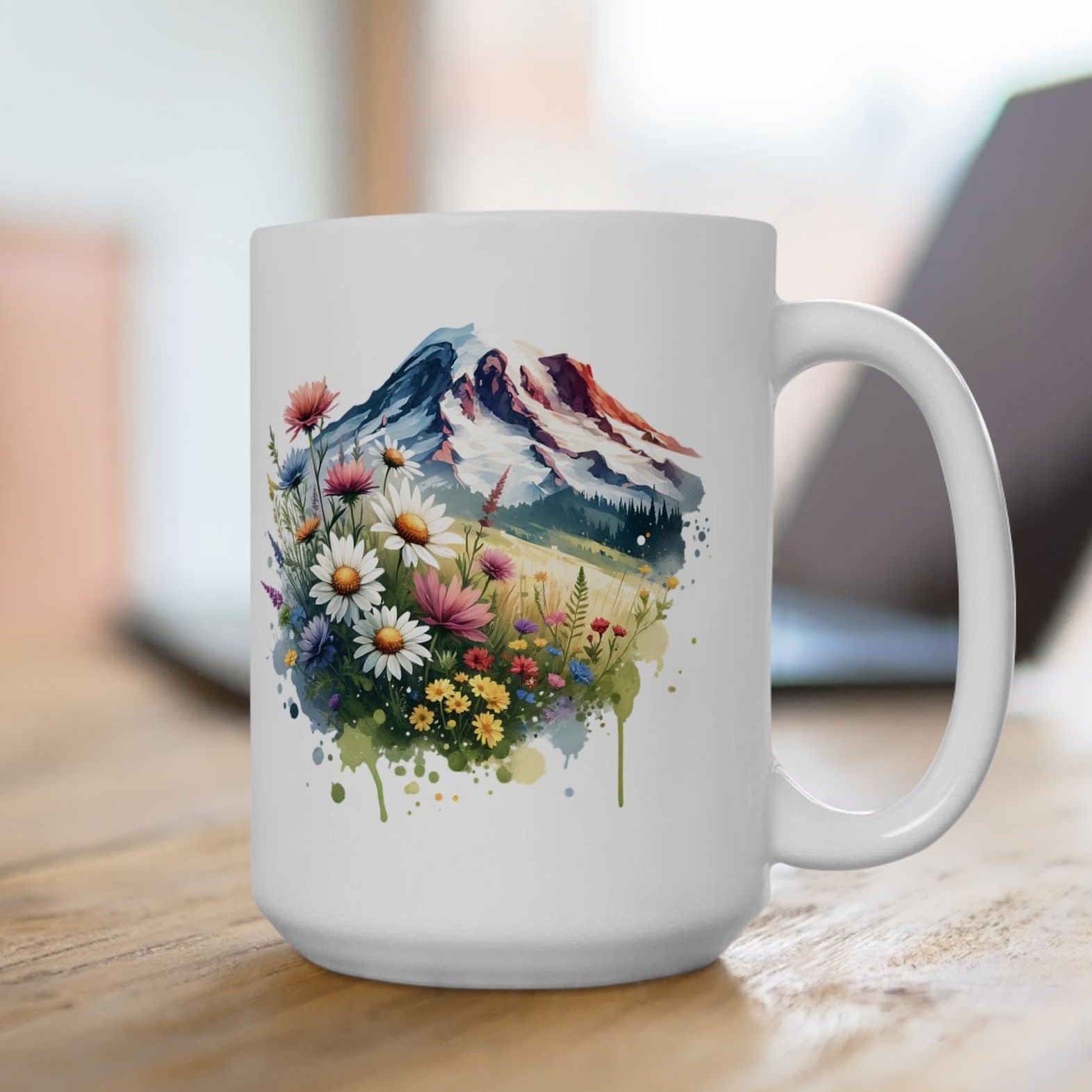 White mug with a mountain and floral design on a wooden surface