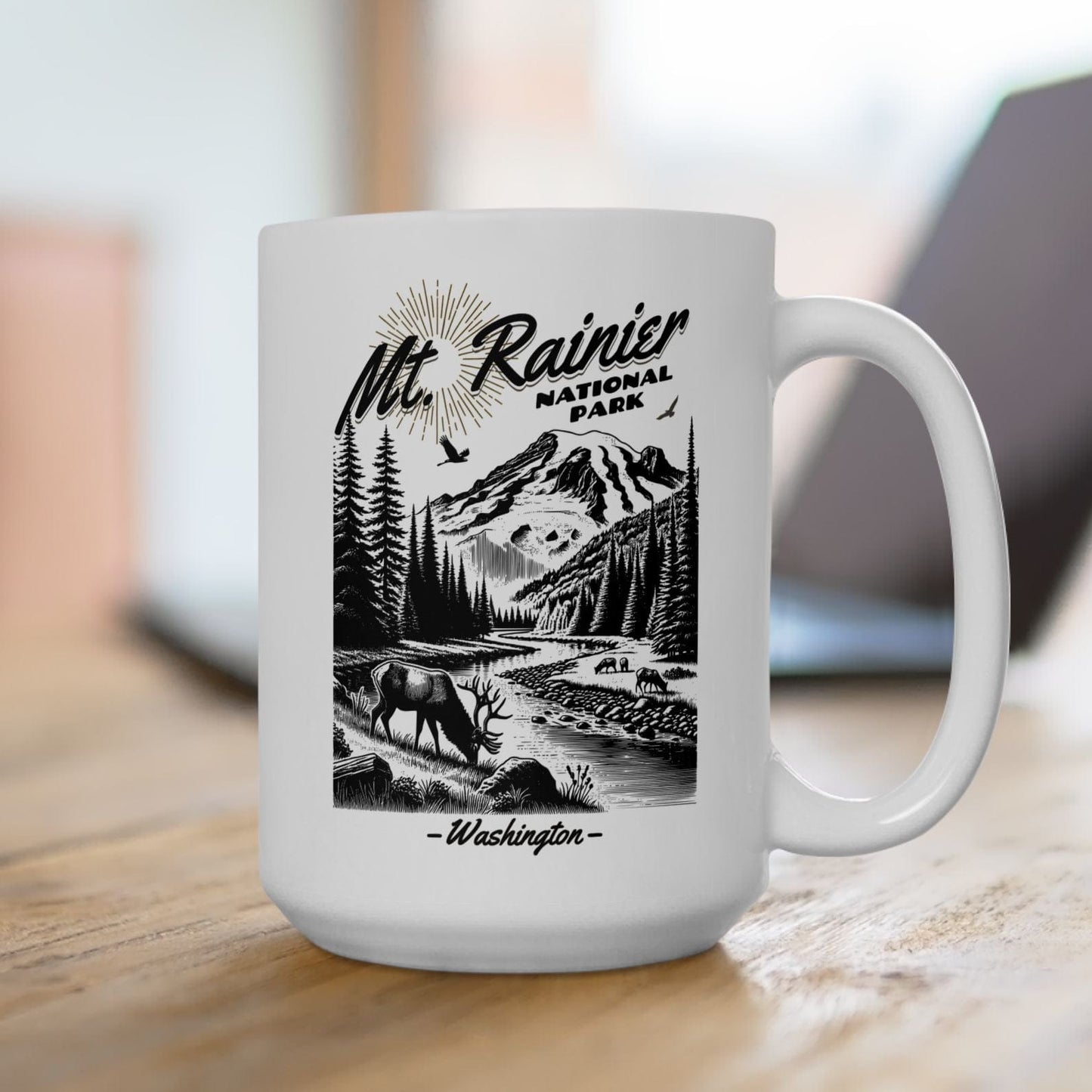 White mug with black mountain and moose design on a wooden surface