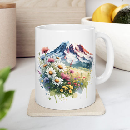 White mug with a scenic design of flowers and mountains on a coaster.