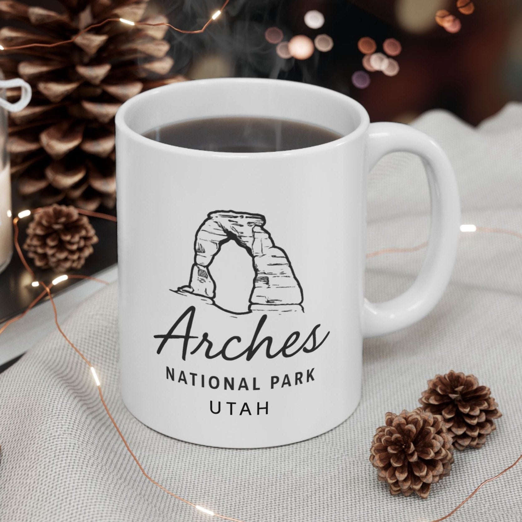 White mug with Arches National Park Utah design on a table with decorative items