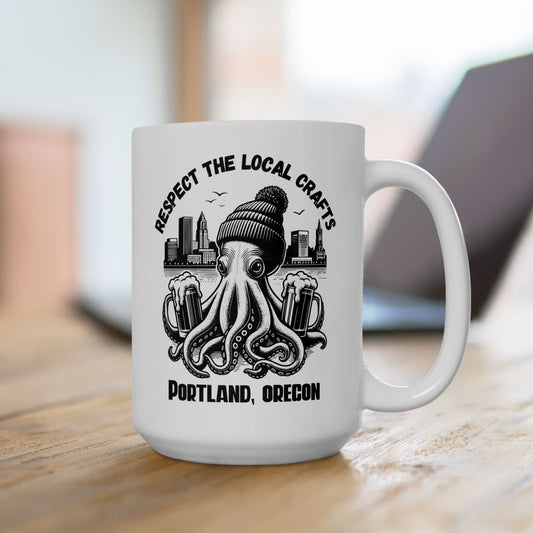 White mug with black graphic design featuring an octopus, beanie, and cityscape, with text 'Respect the Local Crafts Portland, Oregon' on a wooden surface.