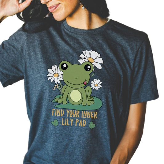 A gray t-shirt with a graphic print of a green frog sitting on a lily pad, surrounded by daisy flowers, with the text 'Find Your Inner Lily Pad' below it.