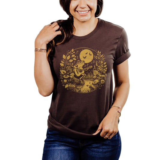 A person wearing a brown t-shirt with a design of a frog playing a guitar.