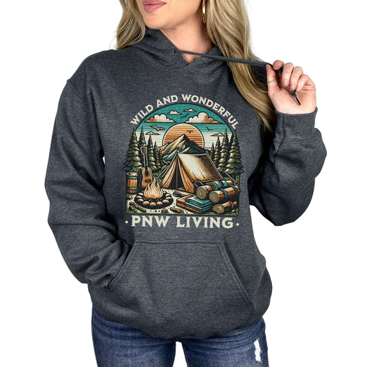 Person wearing a dark gray hoodie with a 'Wild and Wonderful PNW Living' design on a white background
