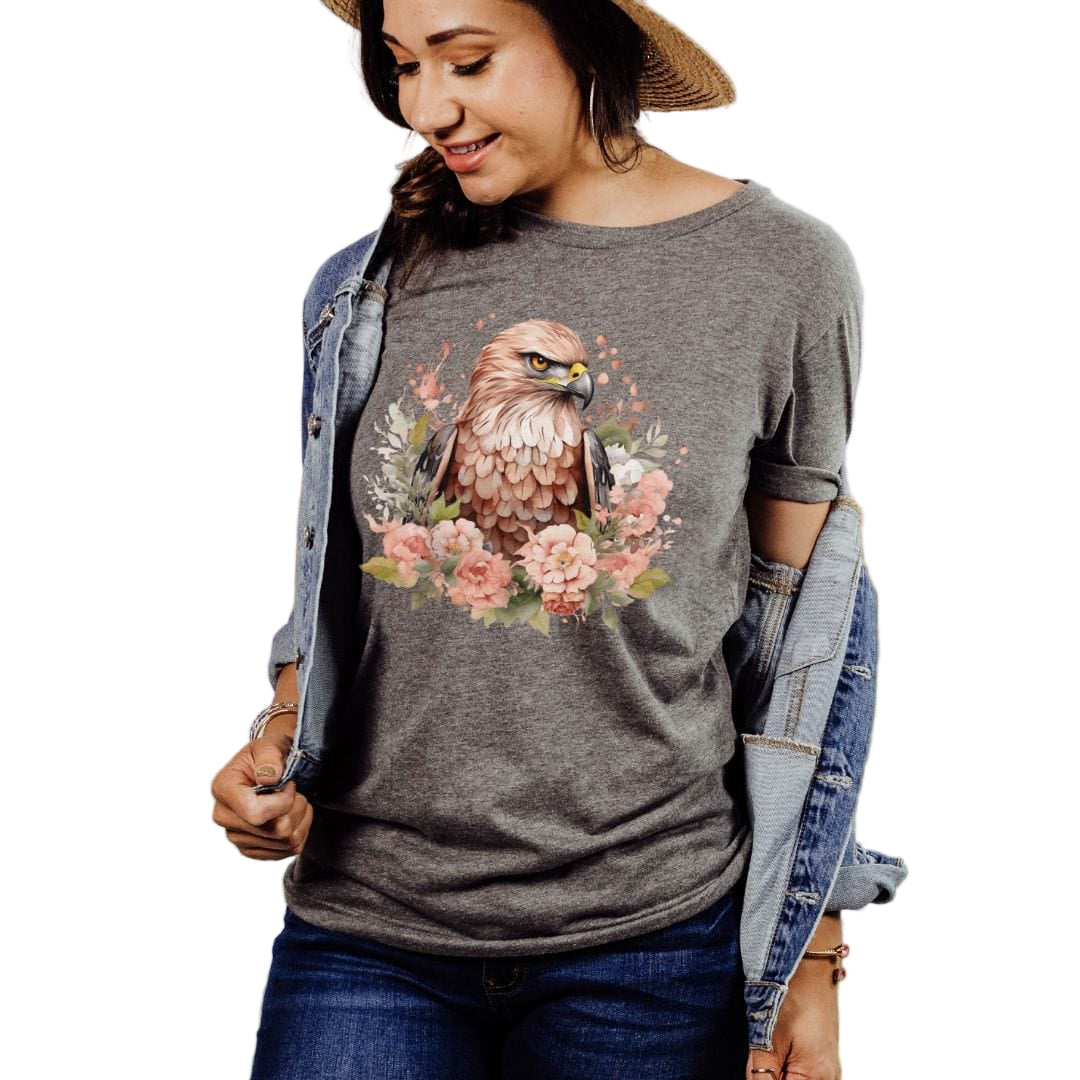 A woman wearing a dark gray heather t-shirt with a floral hawk design and pink flowers.