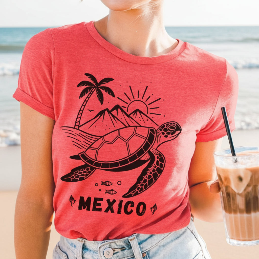 A woman wearing a heather red crew neck t-shirt with a graphic of a turtle, palm trees, and the word 'MEXICO' on it.