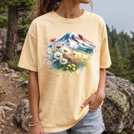 Woman wearing a butter yellow Comfort Colors t-shirt featuring a watercolor Mount Rainier wildflower graphic.
