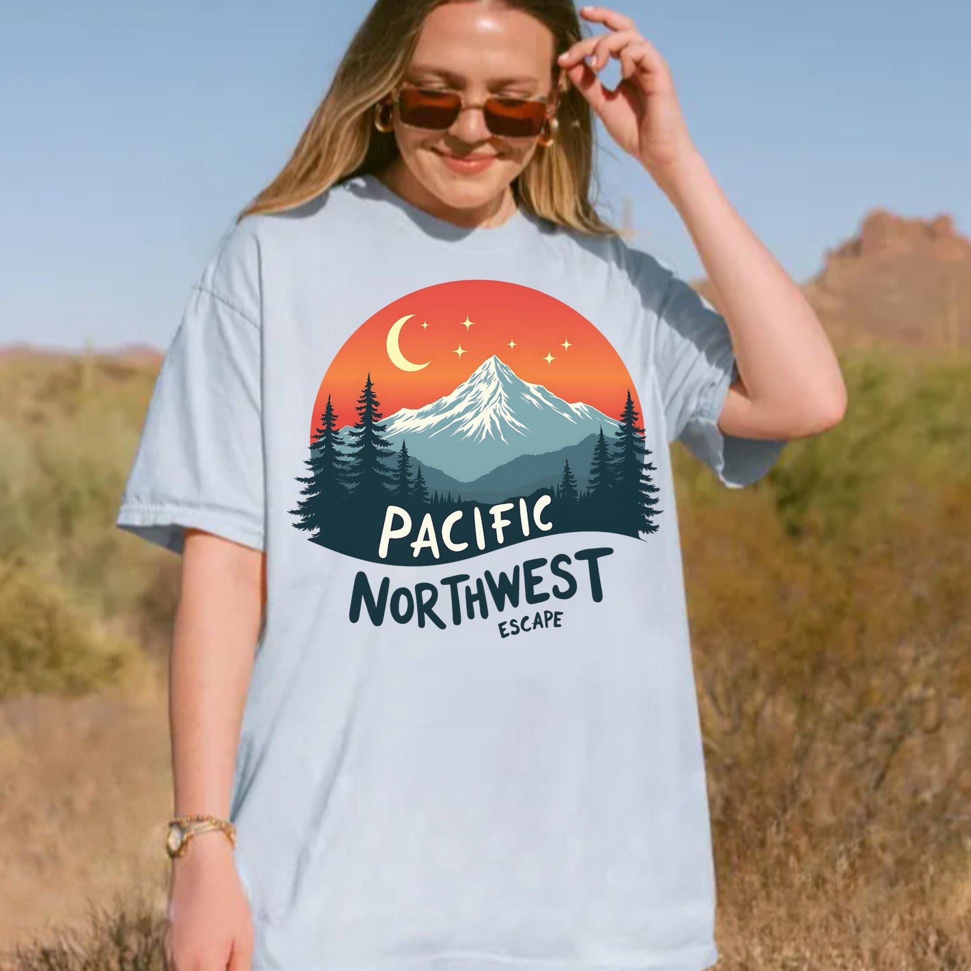 Person wearing a t-shirt with a Pacific Northwest design in a desert setting