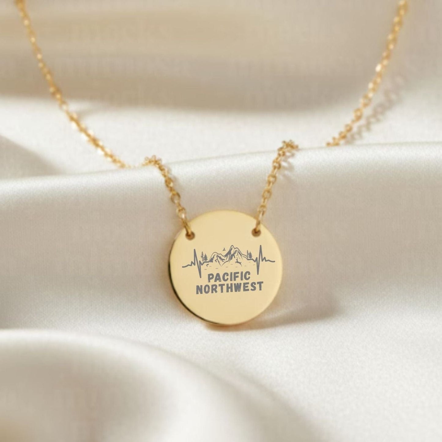 Gold necklace with a round pendant on a beige fabric background