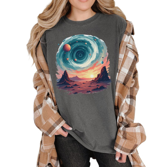 A person wearing a pepper colored t-shirt with a vintage cosmic swirls graphic, paired with a plaid shirt.