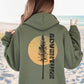 Person wearing a green hoodie with a tree and 'Adventure' text on the beach