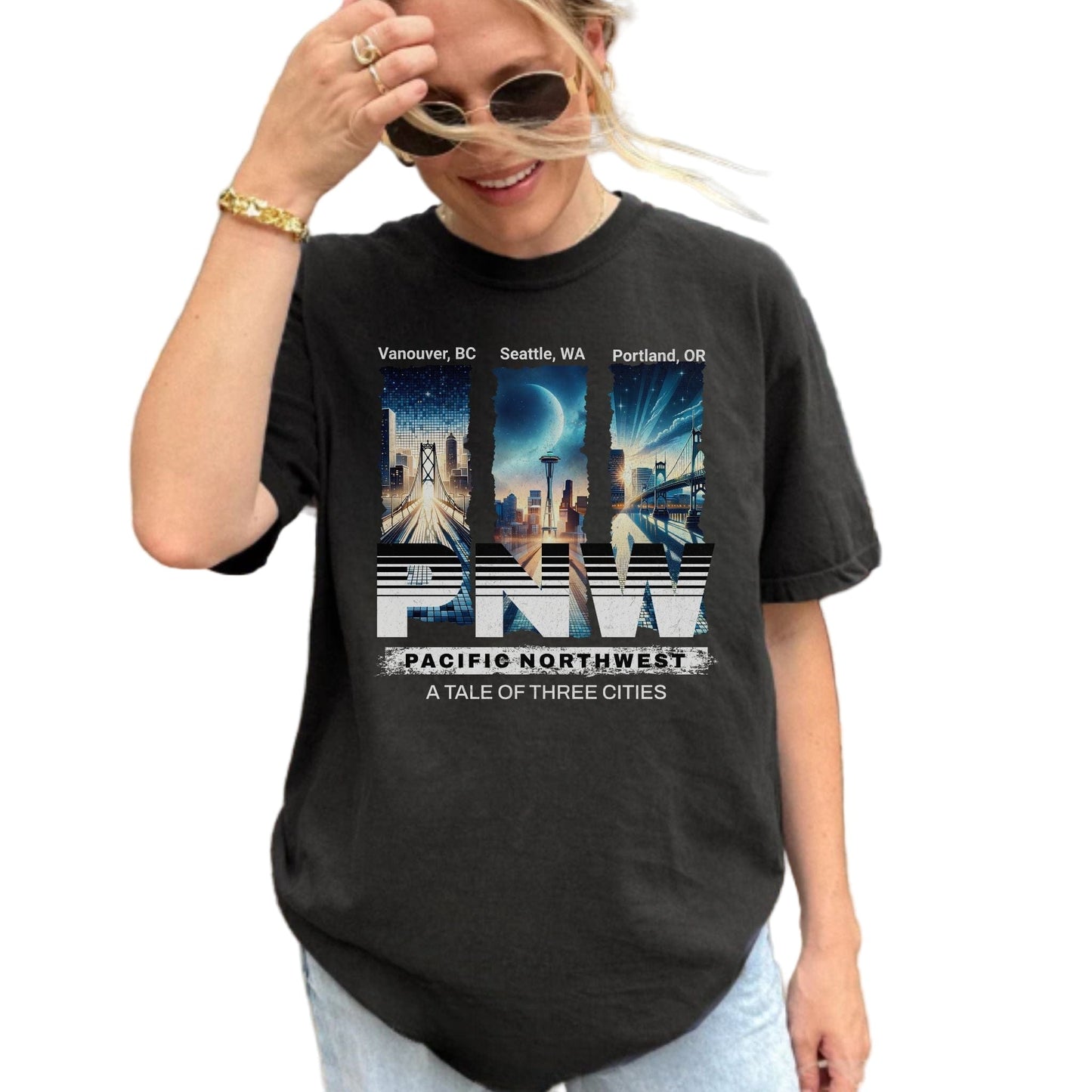 Person wearing a black t-shirt with a Pacific Northwest design outdoors.