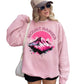 Person wearing a pink sweatshirt with Mount Rainier design.