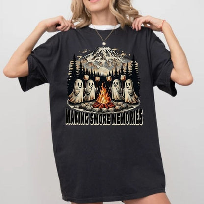 Person wearing a black t-shirt with a graphic of ghosts around a campfire and text 'Making Smore Memories' on a plain background.
