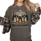 Woman wearing a pepper colored Comfort Colors t-shirt with a vintage illustration of cute ghosts roasting marshmallows by a campfire underneath Mount Rainier Washington.