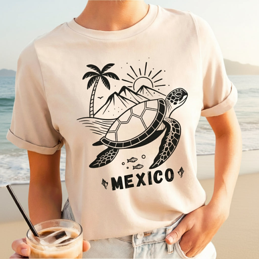 A woman wearing a soft cream colored crew neck t-shirt with a graphic of a turtle, palm trees, and the word 'MEXICO' on it.