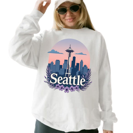 Person wearing a white sweatshirt with a 'Seattle' design featuring the Space Needle.