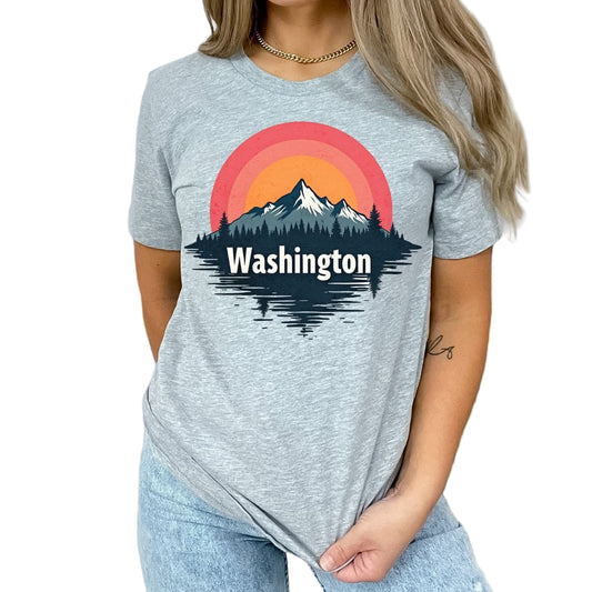 A person wearing a gray t-shirt with a graphic of a sunrise over a mountain range, and the text 'Washington' below it.
