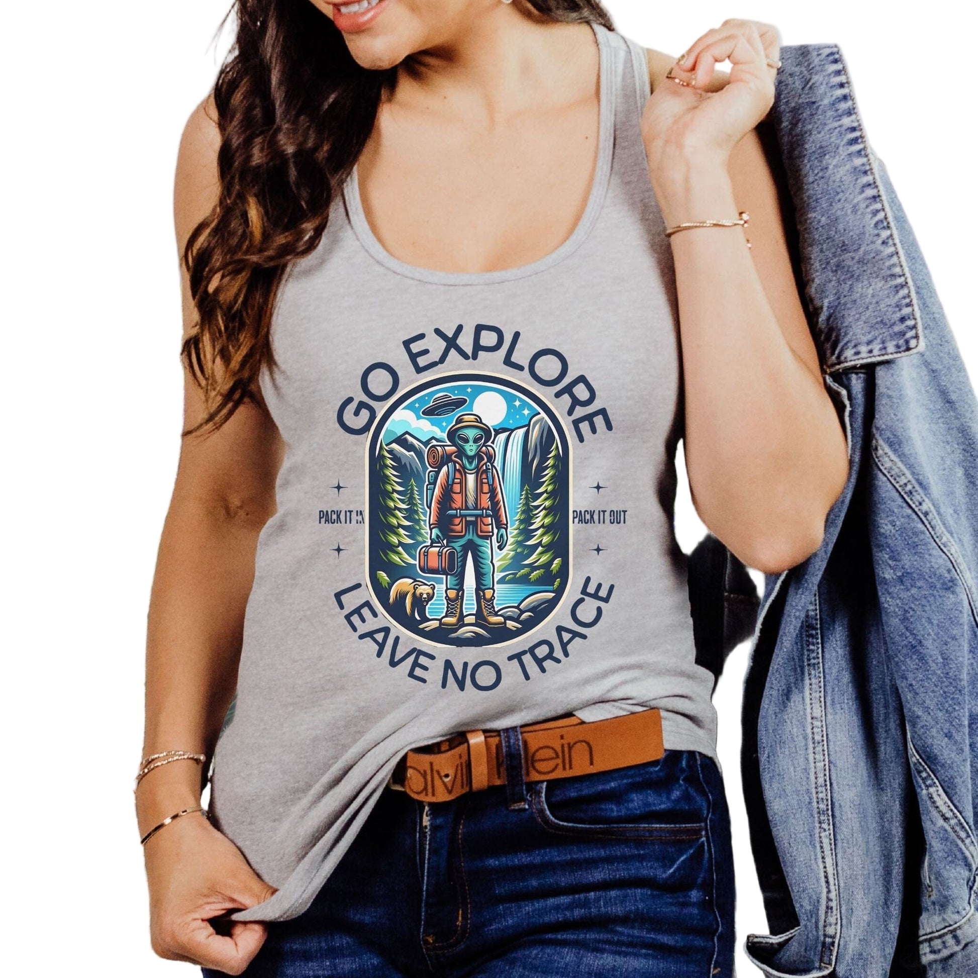 A woman wearing a gray tank top with an alien design and the text 'GO EXPLORE LEAVE NO TRACE' 