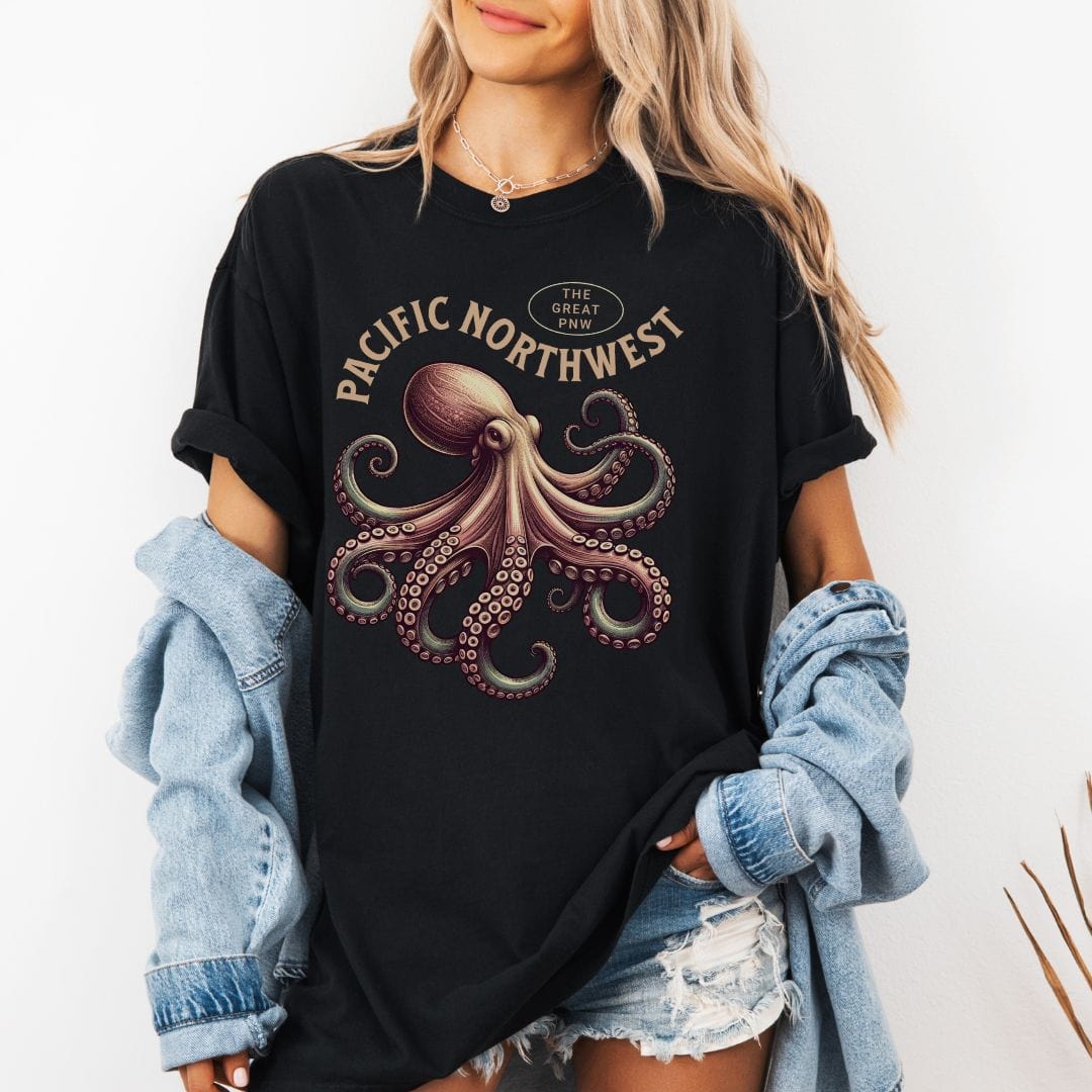 Person wearing a black t-shirt with an octopus graphic and 'Pacific Northwest' text, paired with a plaid shirt.