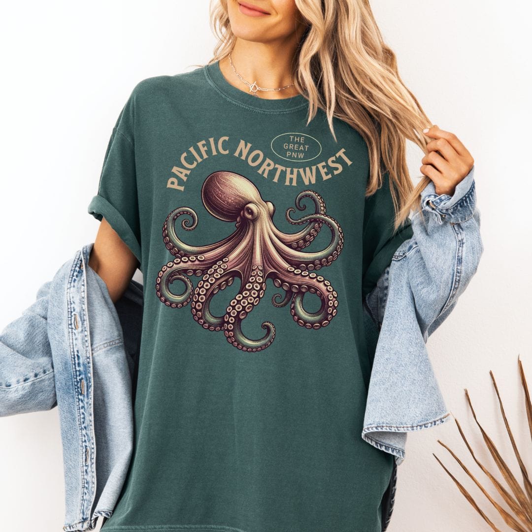 Person wearing a green t-shirt with an octopus graphic and 'Pacific Northwest' text, paired with a plaid shirt.