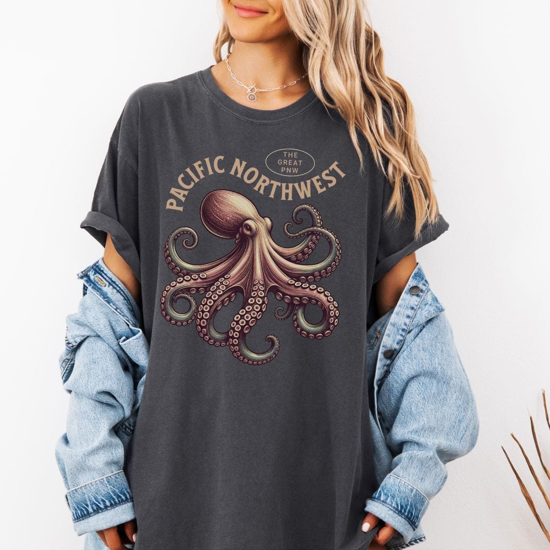 Person wearing a dark gray t-shirt with an octopus graphic and 'Pacific Northwest' text, paired with a plaid shirt.