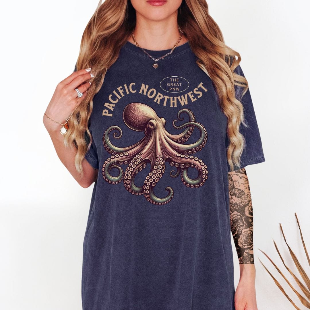 Person wearing a navy blue t-shirt with an octopus graphic and 'Pacific Northwest' text, paired with a plaid shirt.