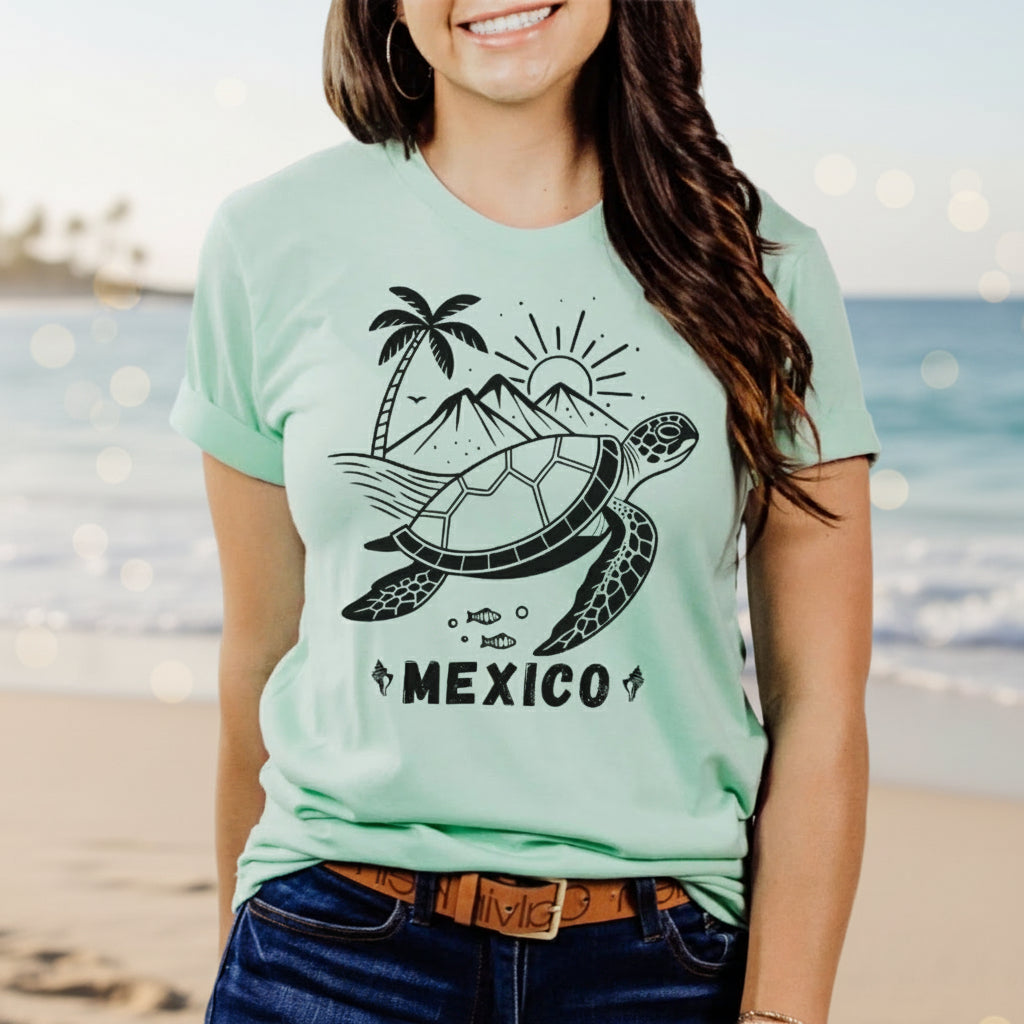 A woman wearing a yellow crew neck t-shirt with a graphic of a turtle, palm trees, and the word 'MEXICO' on it.