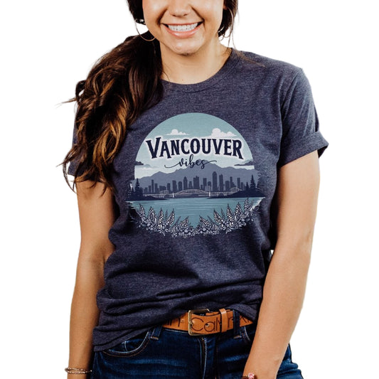 A woman wearing a gray Bella Canvas 3001 nature tee with 'VANCOUVER' printed on the front.