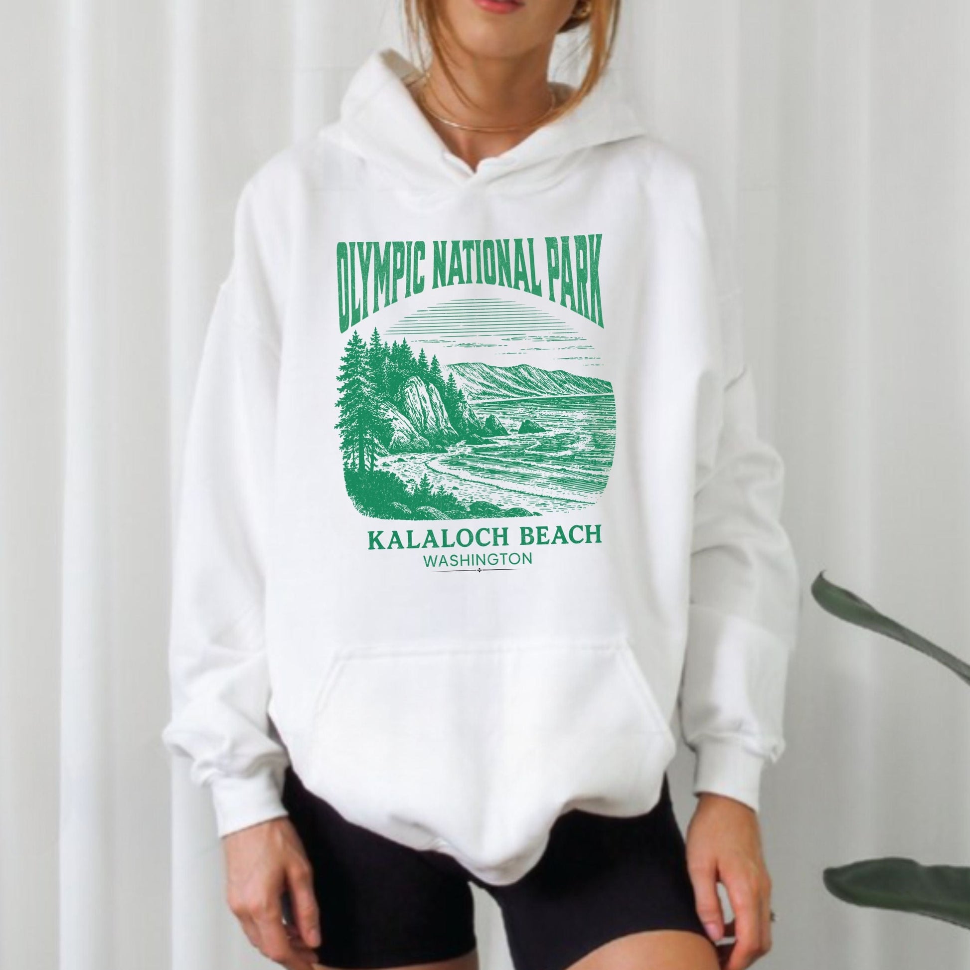 White hoodie with green Olympic National Park graphic and text on a plain background