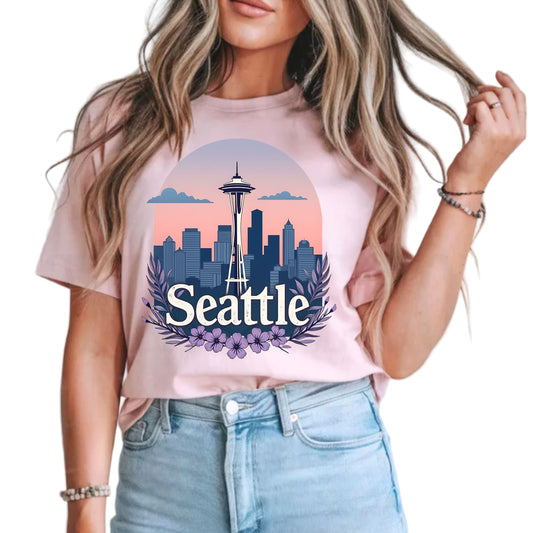 Person wearing a pink t-shirt with a Seattle skyline design.