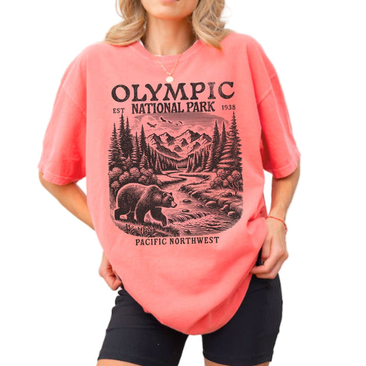 Woman wearing a watermelon colored Comfort Colors t-shirt featuring a highly detailed retro sketch design of a bear and mountains at Olympic National Park Pacific Northwest.