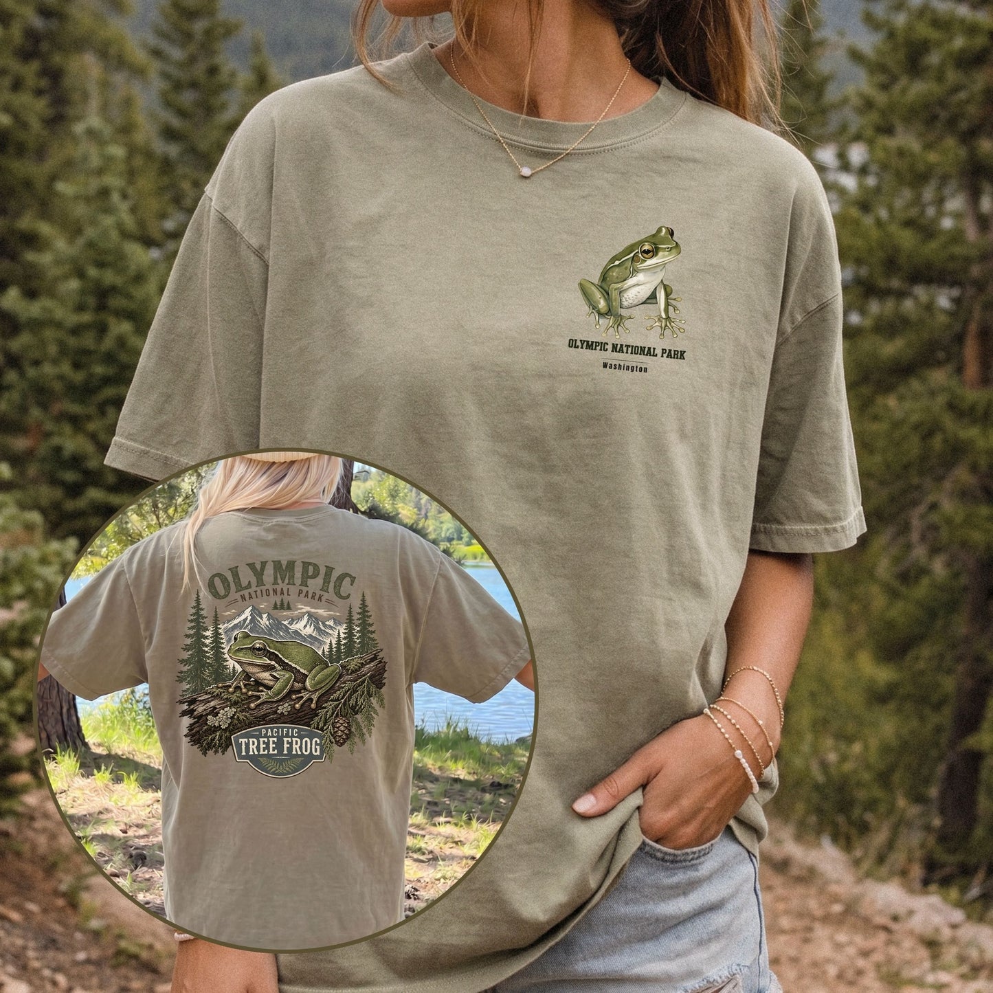 A woman wearing a KHAKI graphic t-shirt in an outdoor forest setting. The t-shirt features a green tree frog and 'Olympic National Park' text on the left chest, and a large matching graphic on the back.