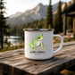 White enamel camp mug with a green frog illustration and Olympic Peninsula, Washington lettering, displayed outdoors on a wooden bench.