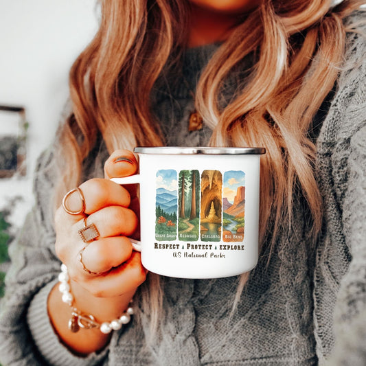 A person in a gray cable-knit sweater holds a white enamel mug featuring colorful landscape designs of National Parks, with the text 'Respect • Protect • Explore' and 'Utah National Parks'.